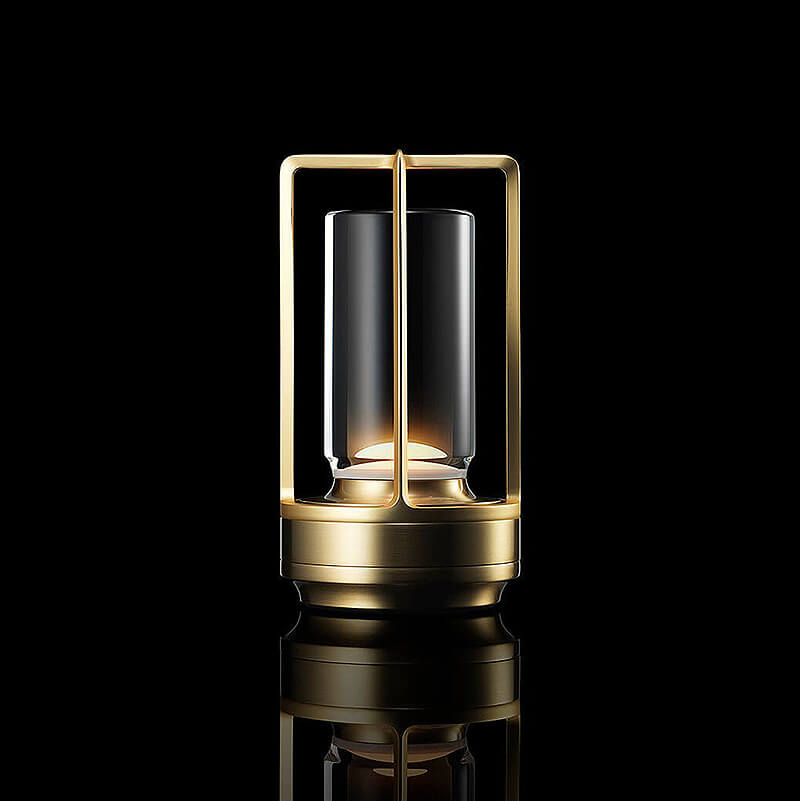 Leuchtende Tischlampe mit goldfarbenem Metallrahmen, Glaszylinder und Sockel vor schwarzem Hintergrund, auf glänzender Fläche gespiegelt. 1
