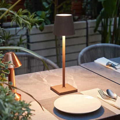 Kupferfarbene Tischlampe auf einem Terrassentisch mit Marmoroptik