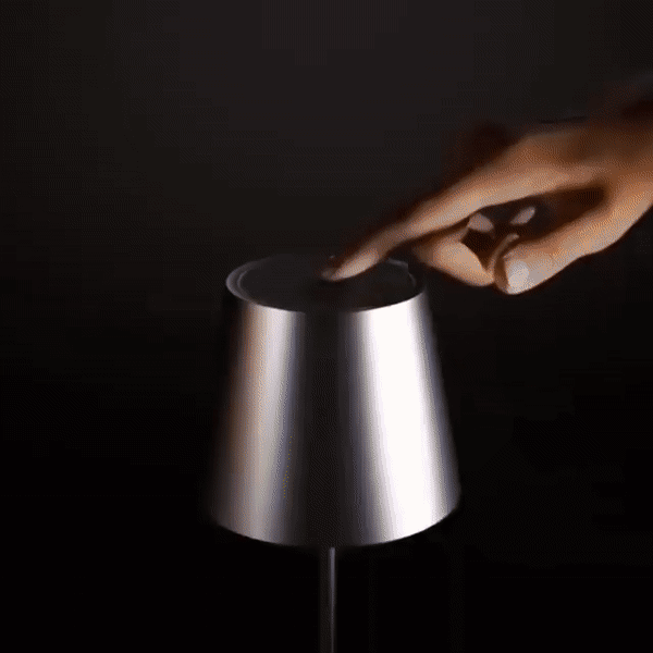 Detail einer silbernen Tischlampe, oben per Touch berührt