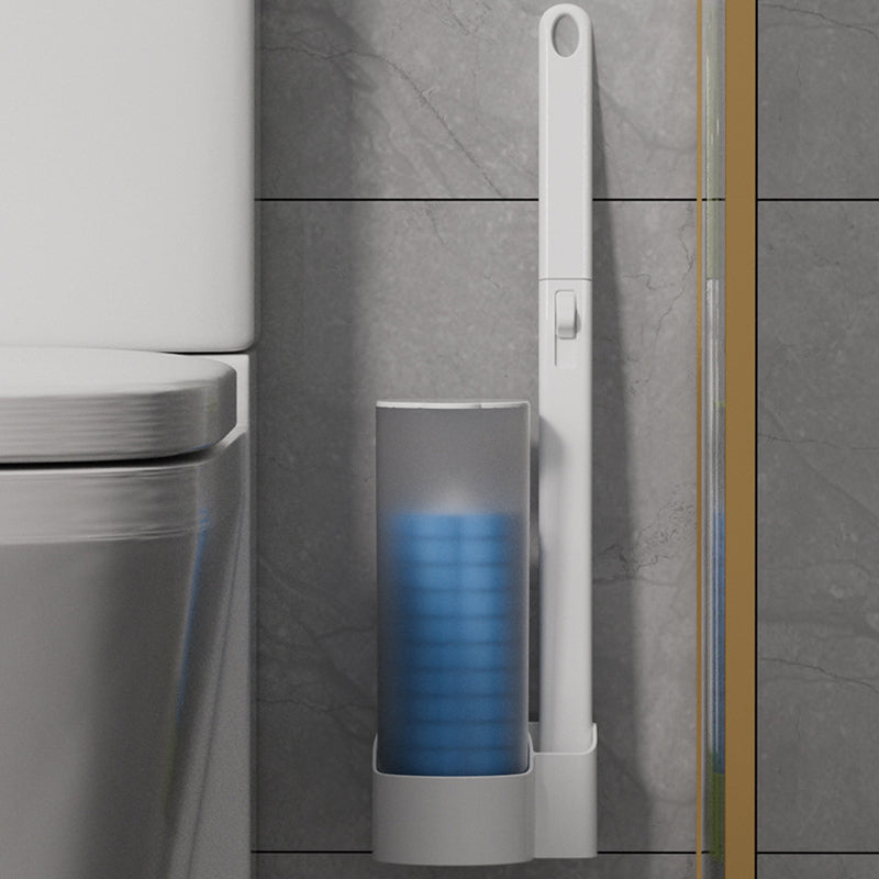 Wandmontierter Spender mit blauen Aufsätzen und angehängtem Stiel neben einer Toilette