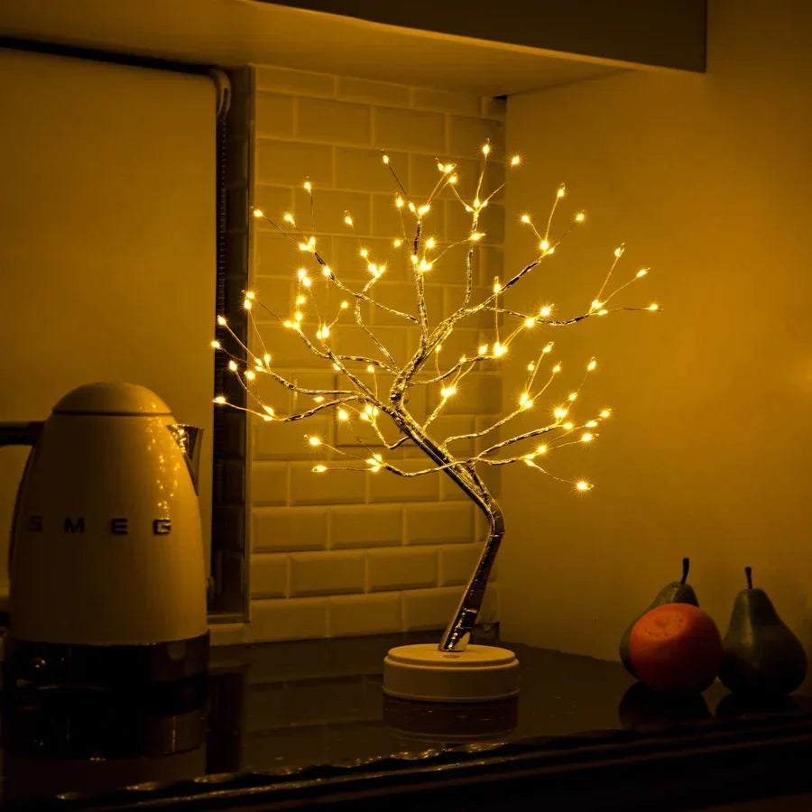 Lichterbaum auf einer dunklen Küchenablage vor weißen Fliesen, daneben ein Wasserkocher und Früchte 5