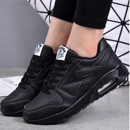 Komplett schwarze Sneaker mit Luftpolster-Sohle, von einem Model zu schwarzer Leggings getragen 2