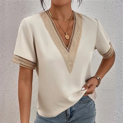 Frau in cremefarbener Bluse mit V-Ausschnitt und Spitzenbesatz, lässiger Sommerlook.