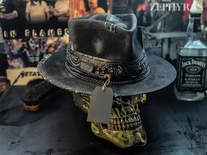 Schwarzer Lederhut mit Kettenband auf goldfarbenem Totenkopf, Rockabilly-Stil, Vintage-Dekor.