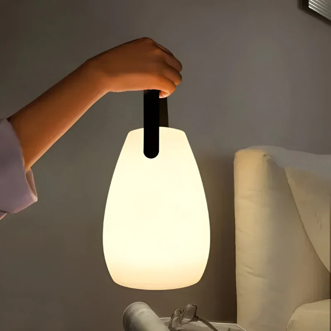 Tragbare LED-Lampe, weiß, mit schwarzem Griff, ideal für Schlafzimmerbeleuchtung.