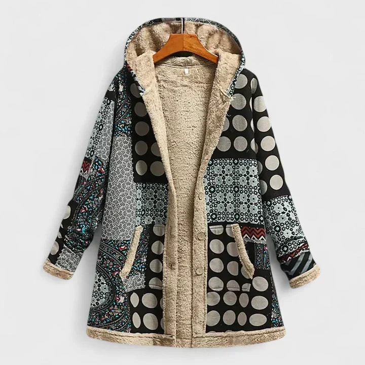 Kapuzenjacke mit schwarzweißem Patchworkmuster aus Punkten und Ornamenten, Knopfleiste und beigem Teddyfutter, auf Holzbügel 4