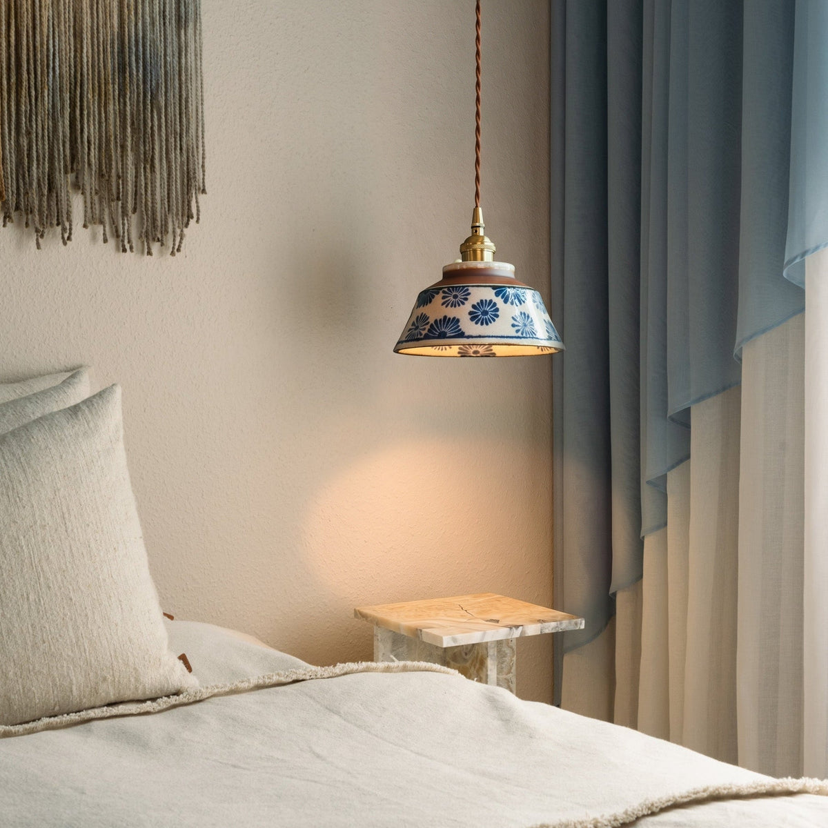Keramik-Pendelleuchte mit blau geblümtem Schirm im Schlafzimmer.
