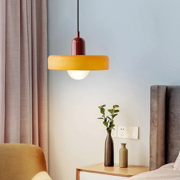 Bauhaus Buntglas-Pendelleuchte mit orangegelbem Schirm und dunkelroter Kappe im Schlafzimmer, another view