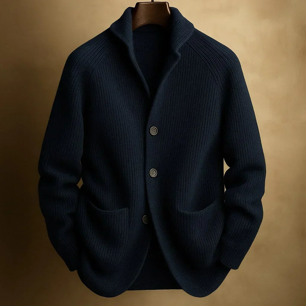 Dunkelblaue Strickjacke mit Schalkragen, drei Knöpfen und zwei Taschen, auf Bügel vor goldbraunem Hintergrund 3