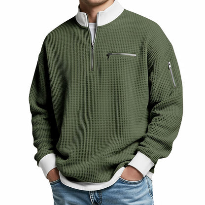 Herrenpullover in Olivgrün mit weißem Stehkragen und Reißverschlusstaschen, frontal am Model.