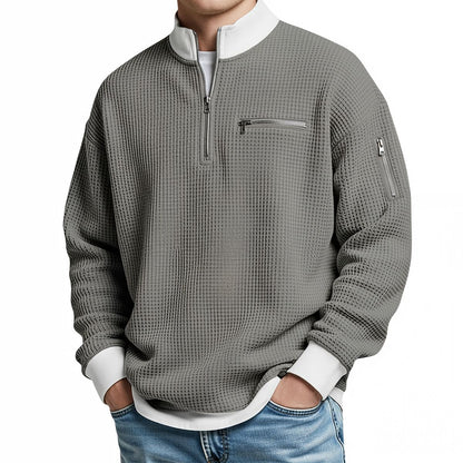 Herrenpullover in Mittelgrau aus Waffelstrick mit weißem Kragen und weißen Bündchen, frontal am Model.