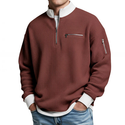 Herrenpullover in Rostrot mit weißem Kragen und weißen Bündchen, frontal am Model.