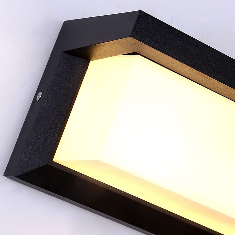 Nahaufnahme der Wandleuchte mit schwarzem Rahmen, Schraube und mattweißem, warm leuchtendem Lichtkörper 2