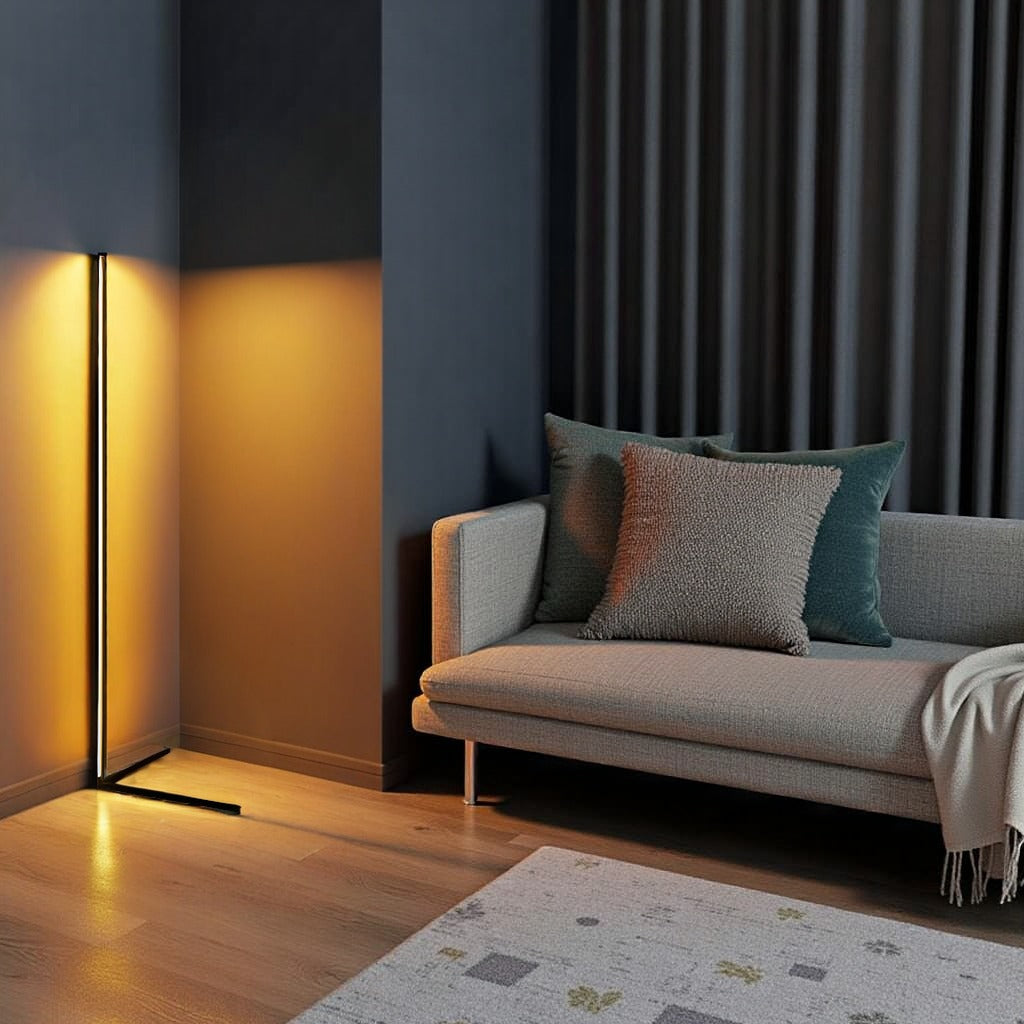 Stehlampe mit goldenem Licht in dunkelblauer Zimmerecke neben einem grauen Sofa mit Kissen 11