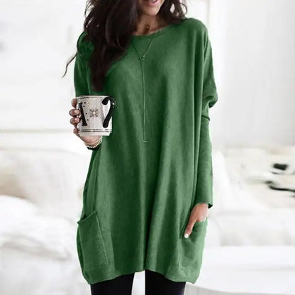 Frau in grünem Langarm-Tunika-Top mit Taschen, hält Tasse, lässige Damenmode.