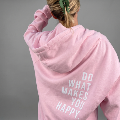 Rosa Hoodie von hinten getragen, Frau mit grüner Haarklammer greift sich an den Kopf, heller Rückenaufdruck im Fokus. 1