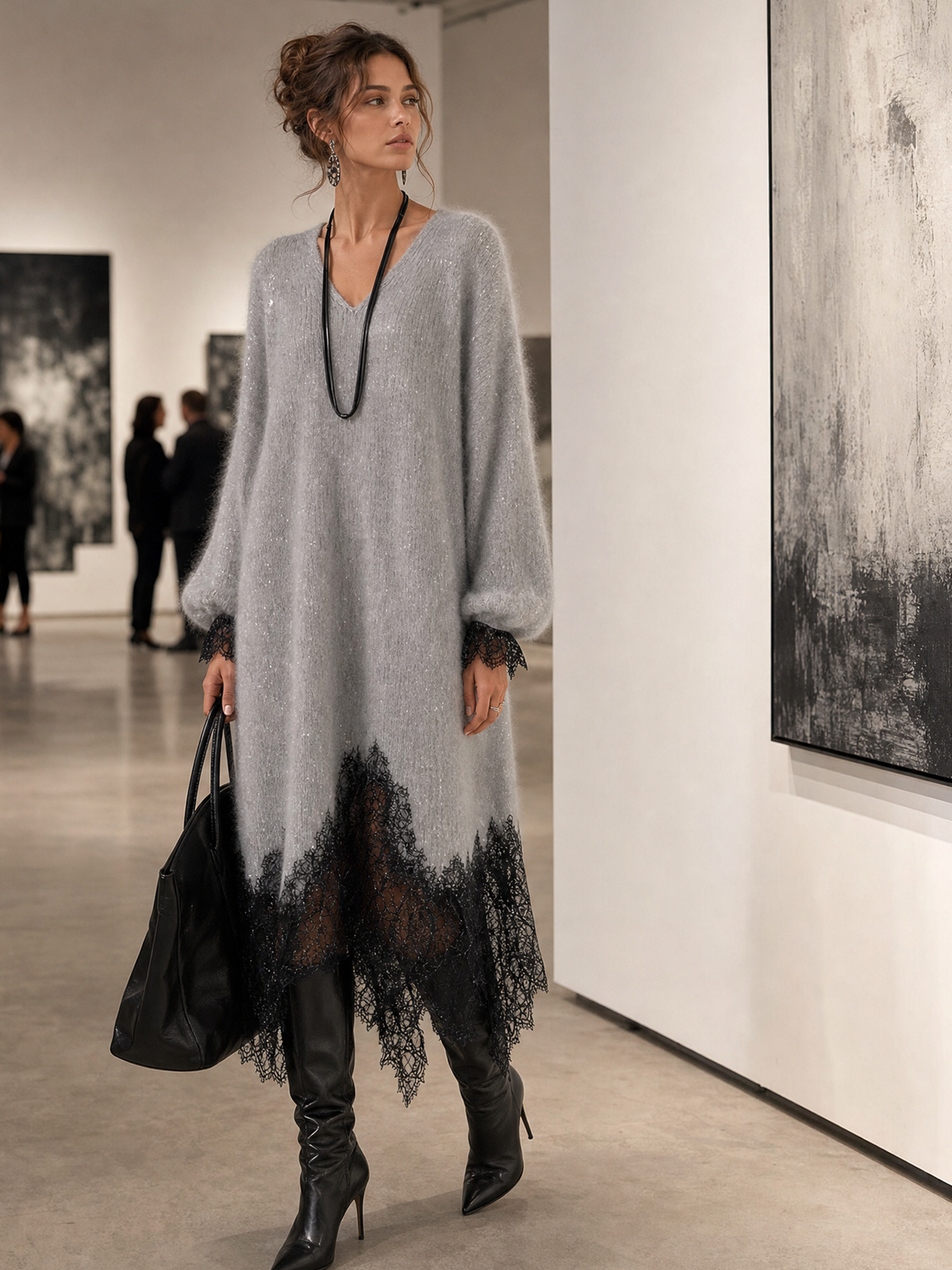 Frau im grauen Strickkleid mit Spitzensaum beim Betrachten von Bildern in einer Galerie 3