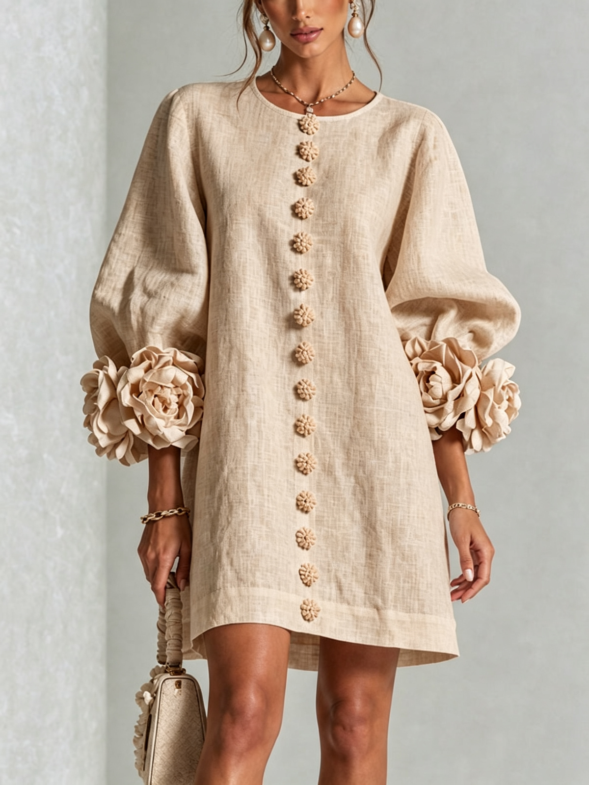 Das Kleid in hellem Beige, Frontansicht mit Puffärmeln und großen Stoffblüten 6
