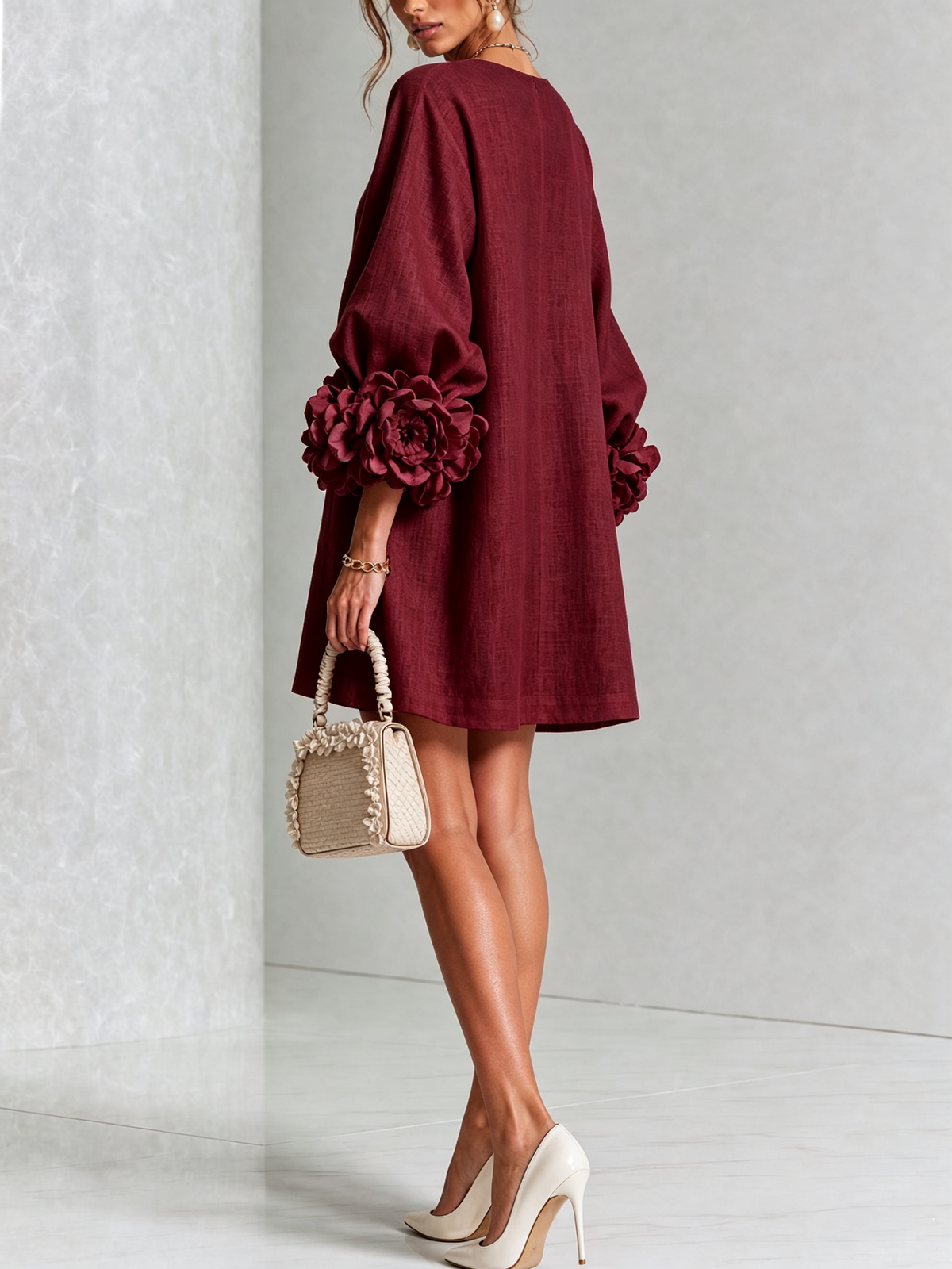 Weinrotes Minikleid von hinten, glatter Rückenteil, Puffärmel mit Rosenmanschetten, Handtasche mit Rüschenrand und cremefarbene Pumps. 37