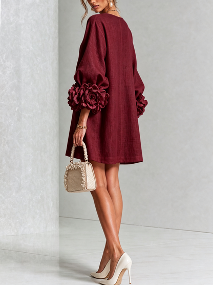 Weinrotes Minikleid von hinten, glatter Rückenteil, Puffärmel mit Rosenmanschetten, Handtasche mit Rüschenrand und cremefarbene Pumps. 37