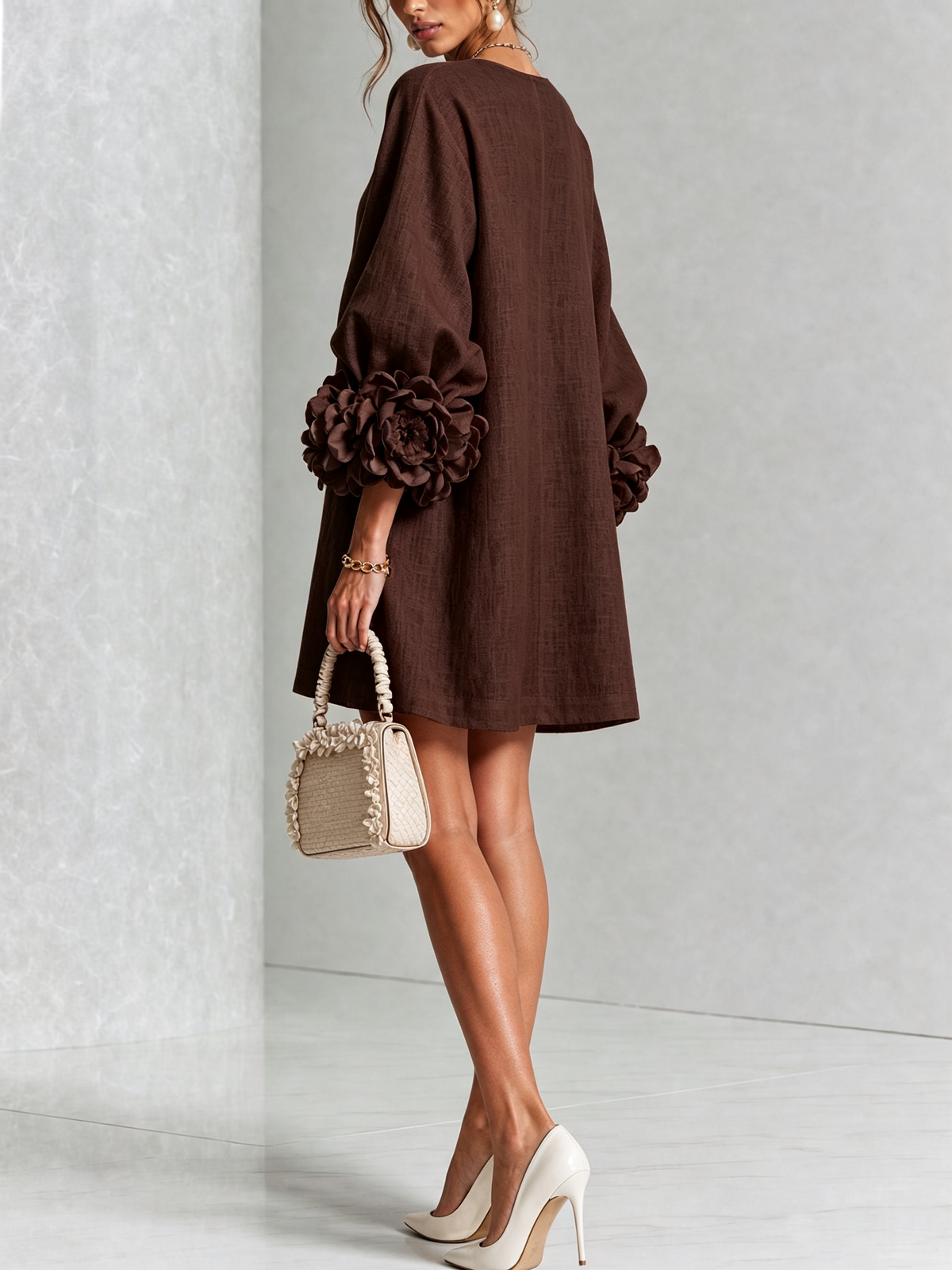 Dunkelbraunes Minikleid von hinten, glatter Rücken, Puffärmel mit dunklen Rosenmanschetten, Handtasche mit Rüschen in der Hand. 29