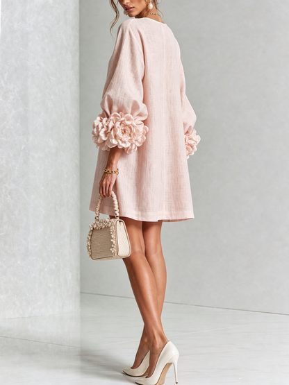 Rosa Minikleid von hinten getragen, Puffärmel mit großen Rosenmanschetten, dazu cremefarbene Handtasche und Pumps vor hellem Marmorhintergrund. 21