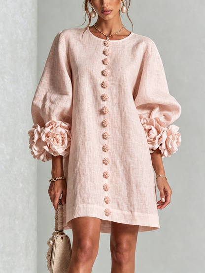 Frontansicht des Minikleids in zartem Rosa mit Puffärmeln, großen Rosenmanschetten und Reihe floraler Knöpfe, getragen von einem Model. 19