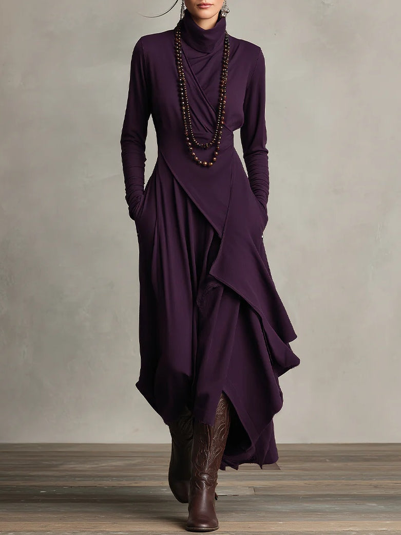 Frontansicht des aubergine-violetten Kleids mit Rollkragen, Wickeloptik und Perlenkette, getragen mit braunen Stiefeln 1