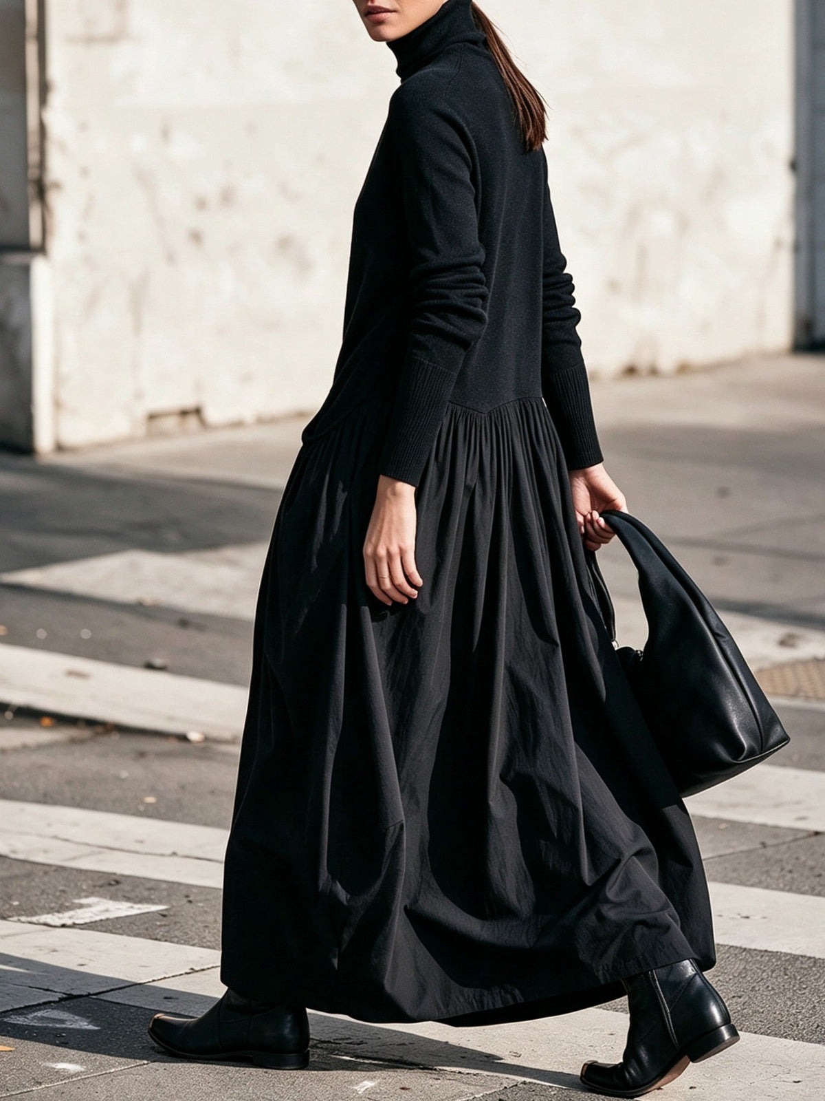Schwarzes Kleid im Gehen von der Seite, mit gerafftem Rock und Strickärmeln mit Rippbündchen 2
