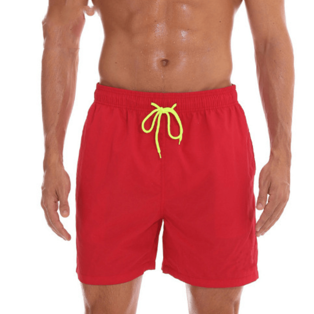 Rote Herren-Badeshorts mit neongelber Kordel, getragen von einem Model vor weißem Hintergrund.