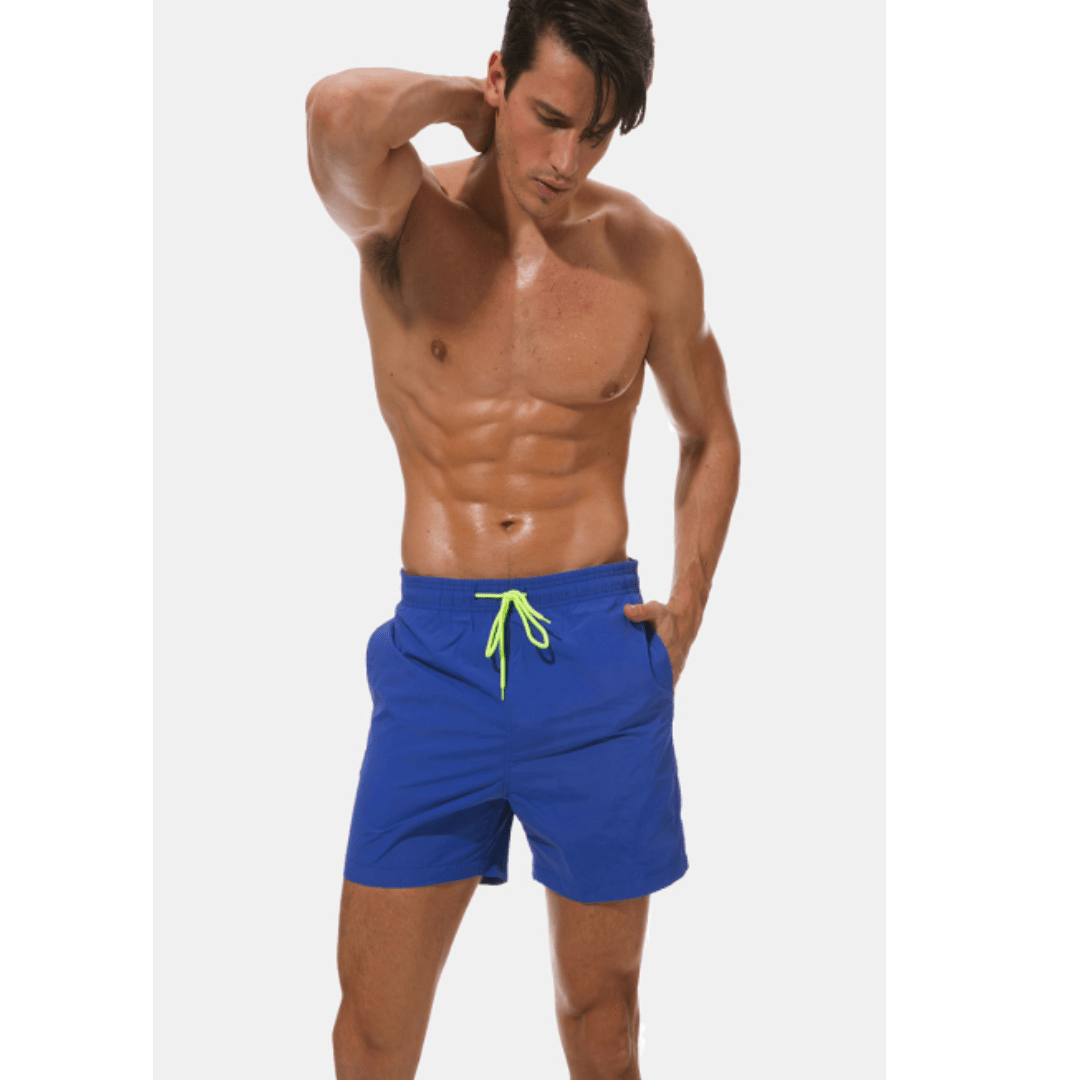 Königsblaue Herren-Badeshorts mit neongelber Kordel, getragen von einem Model vor hellem Hintergrund.