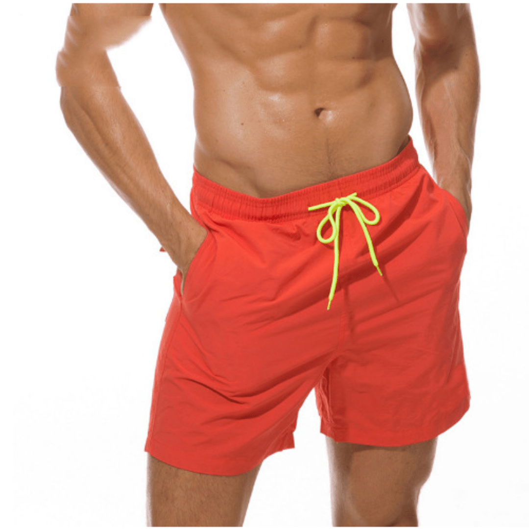 Rote Herren-Badeshorts mit neongelber Kordel, getragen, Frontansicht vor weißem Hintergrund.