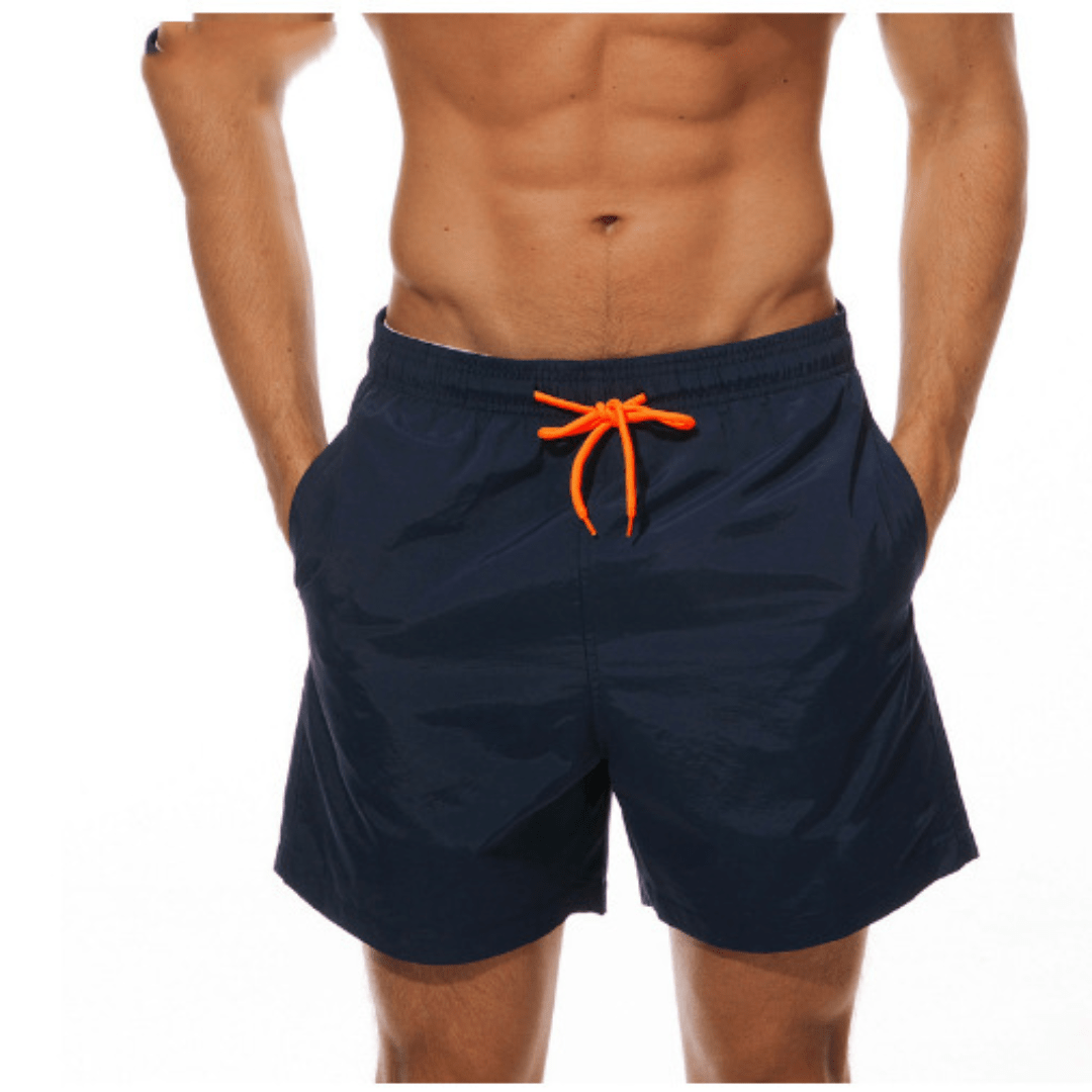 Dunkelblaue Herren-Badeshorts mit orangefarbener Kordel, getragen, Frontansicht vor weißem Hintergrund.