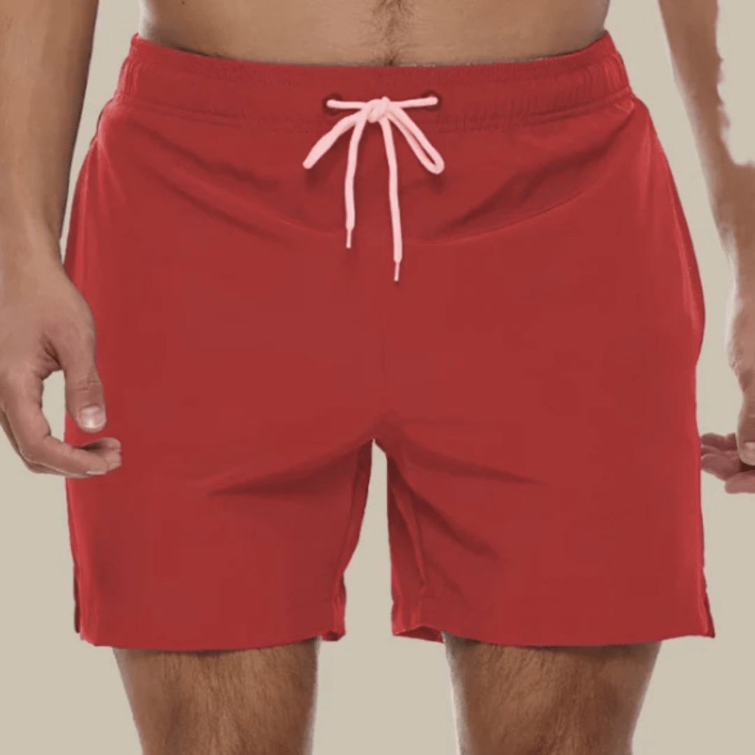 Rote Herren-Badeshorts mit hellrosa Kordel am Elastikbund, Frontansicht als Nahaufnahme.