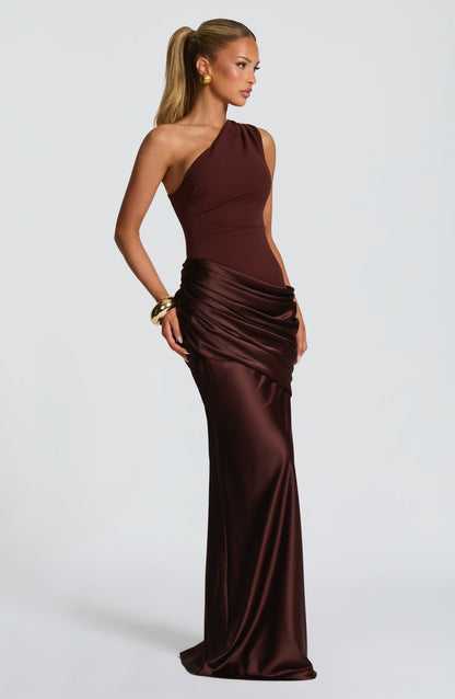 Seitliche Dreiviertelansicht des braunen One-Shoulder-Maxikleids aus Satin mit Drapierung an der Hüfte.