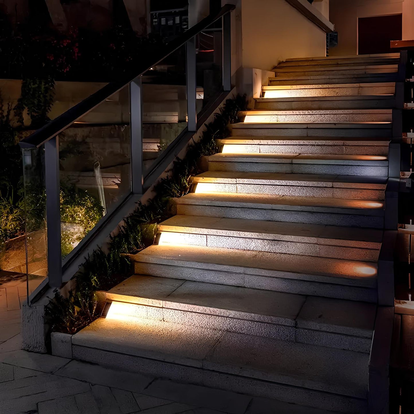 Beleuchtete Außentreppe bei Nacht, moderne LED-Stufenbeleuchtung, Glasgeländer, stilvolle Architektur.