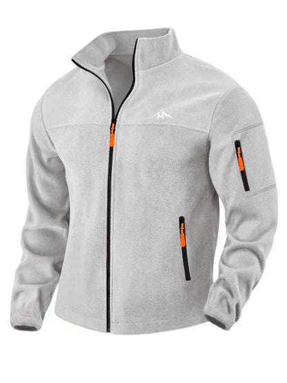 Hellgraue Fleecejacke in Vorderansicht mit Stehkragen, orangefarbenen Zippern und Ärmeltasche 4