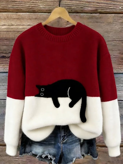 Rot-weißer Flauschpullover mit schwarzer Katze auf Kleiderbügel vor Holzwand, darunter Jeansshorts 7