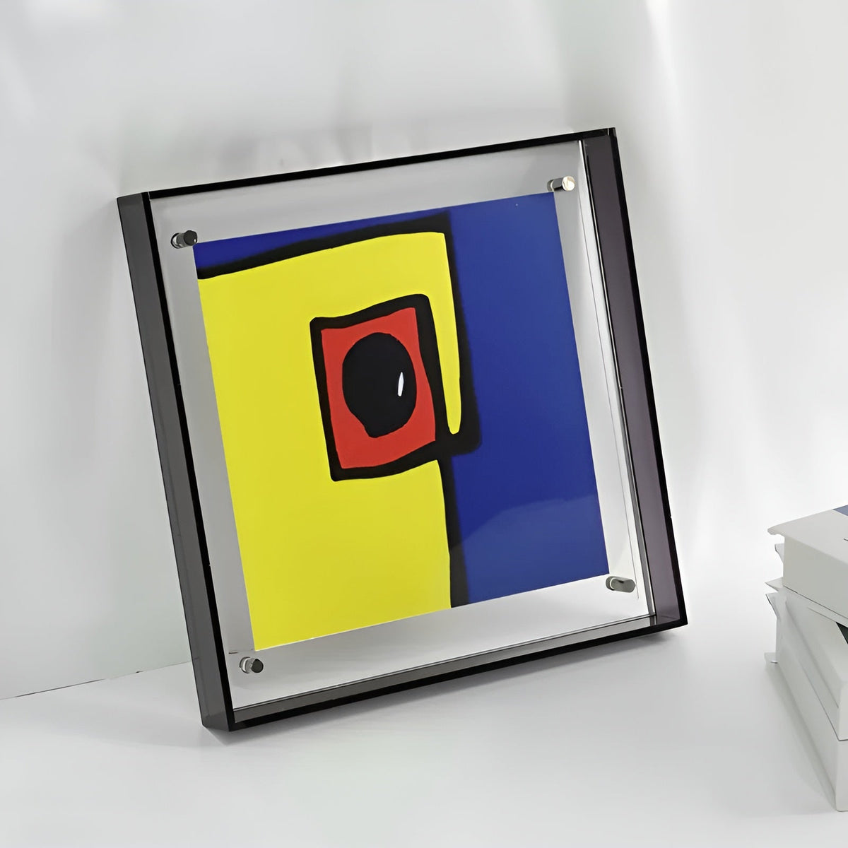 Quadratischer Acrylrahmen mit dunklem Rand und abstraktem Bild an der Wand