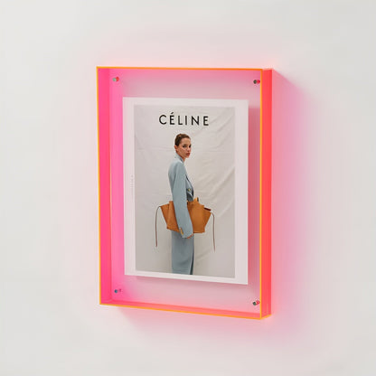 Neonpinker Acrylrahmen an der Wand mit Foto einer Frau im hellblauen Anzug
