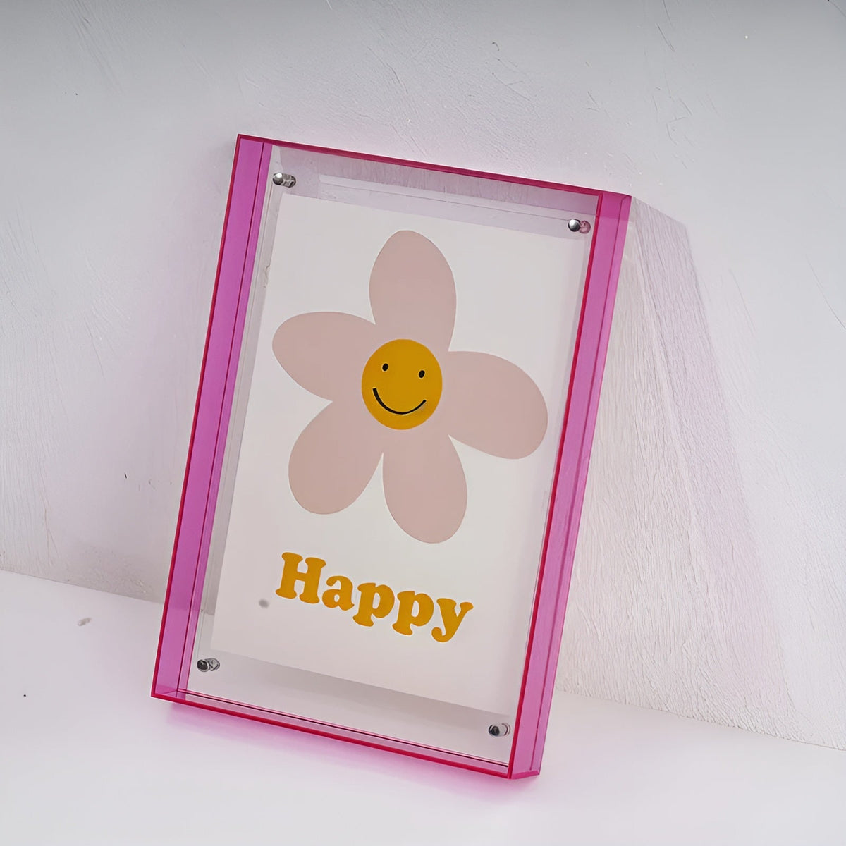 Pinker Acrylrahmen mit Blumenmotiv und lächelndem Gesicht an einer hellen Wand