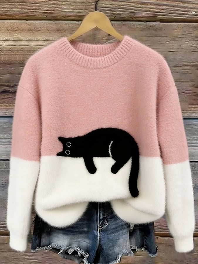 Flauschiger Pullover in Rosa mit weißem Saum und aufgenähter schwarzer Katze, am Holzbügel hängend 2