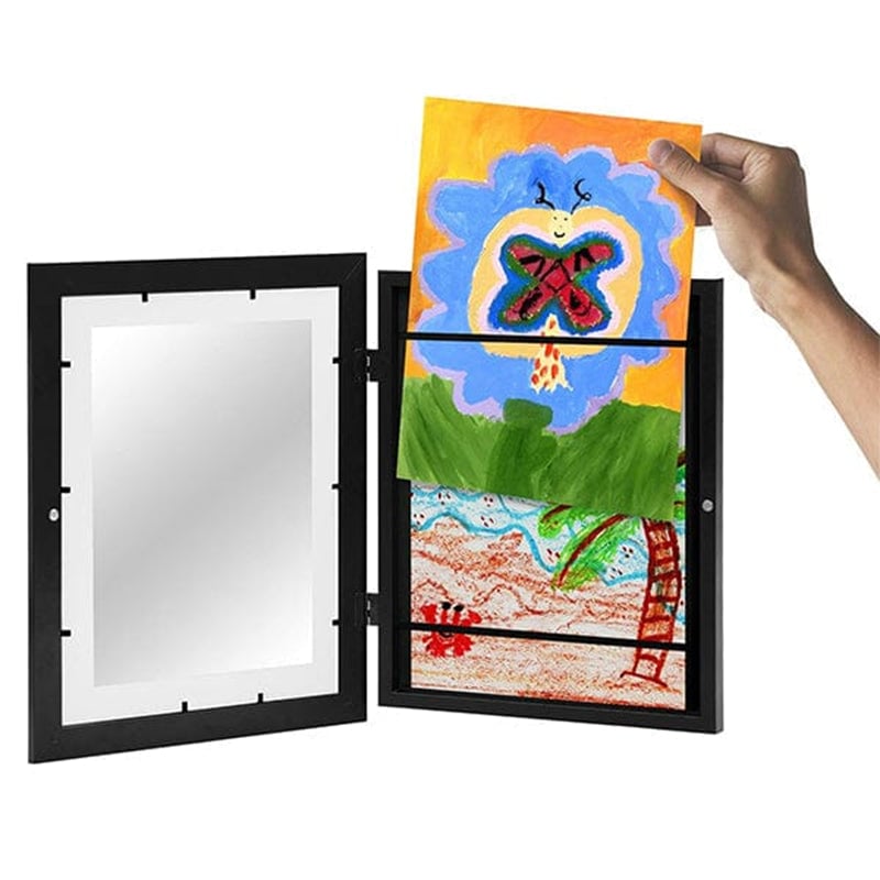 Schwarzer Rahmen mit aufgeklappter Glasfront, eine Hand schiebt eine bunte Kinderzeichnung mit Schmetterling in das Fach, ein zweites Bild liegt darunter. 7