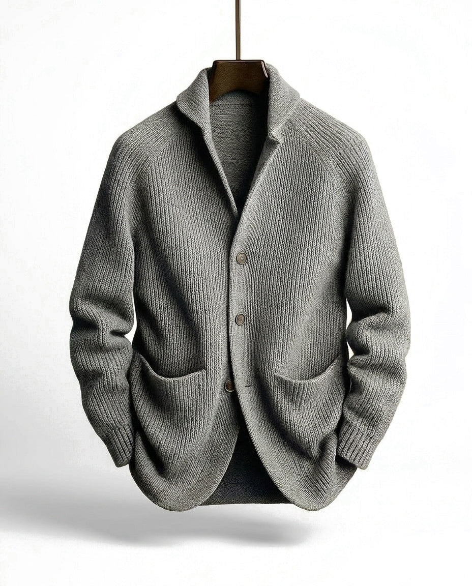 Graue Strickjacke mit Raglanärmeln, Knopfleiste und Schalkragen, frontal am Holzbügel aufgehängt. 4