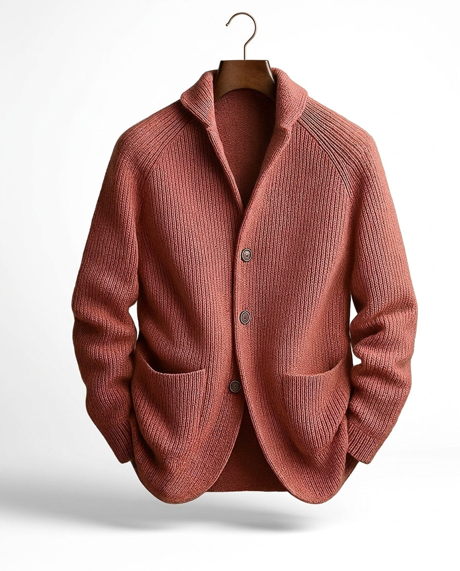 Rostrote Strickjacke in Rippstrick mit drei Knöpfen und Taschen, frontal am Holzbügel hängend. 6