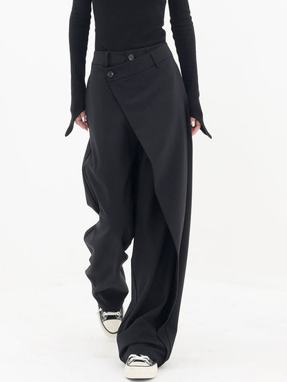 Frau trägt schwarze asymmetrische Baggy-Hose, modisch, elegant, mit Sneakers.