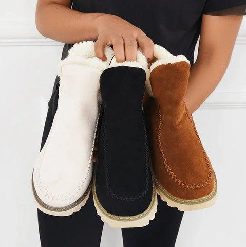 Drei Damen-Stiefeletten in Beige, Schwarz und Braun mit weißem Plüschfutter, nebeneinander in den Händen gehalten.