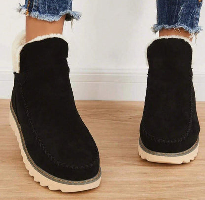 Schwarze Damen-Stiefeletten mit weißem Plüsch am Schaft und Ziernaht an der Schuhspitze, Vorderansicht.