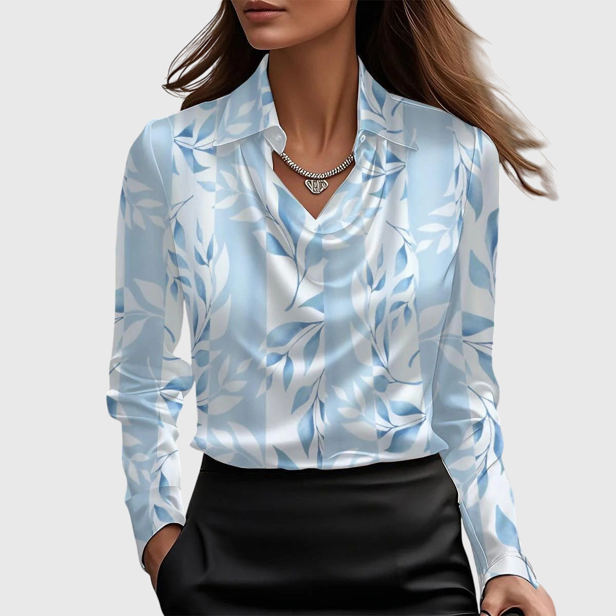 Damen Bluse in Hellblau und Weiß mit Blättermuster, Wasserfallausschnitt und Kragen, dazu schwarzer Rock.