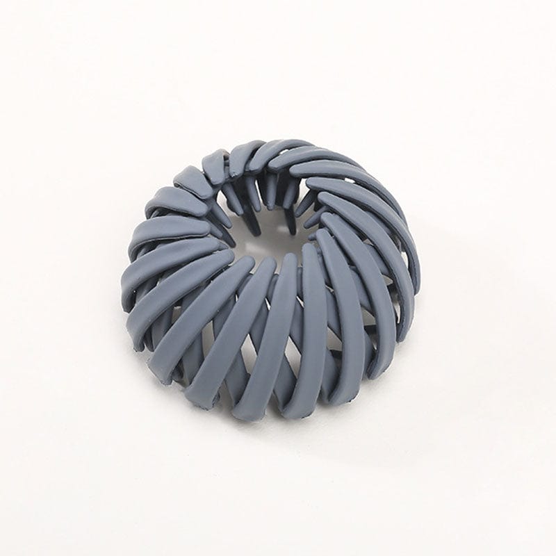 Matte Haarklammer in Graublau mit spiralförmig angeordneten Rippen, einzeln vor hellem Hintergrund.